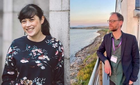 A person stands against a stone wall, wearing a dark floral-patterned sweater with various flowers in shades of pink, white, and green. A person in a dark blazer and green shirt leans against a railing by a serene coastal landscape during sunset.