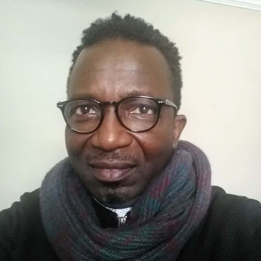 A Black and Scottish man of Sierra Leonean descent wearing a dark scarf and coat. This is Amadu Khan.